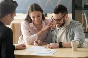 young couple signing estate planning documents