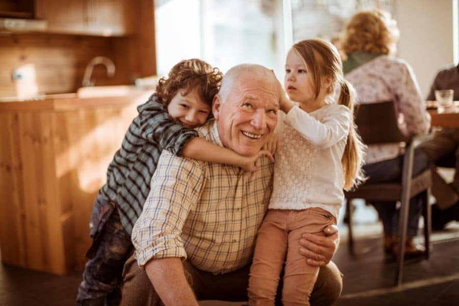 How-To-Divide-Possessions-Among-Heirs a grandfather playing on the floor with his two young grandchildren