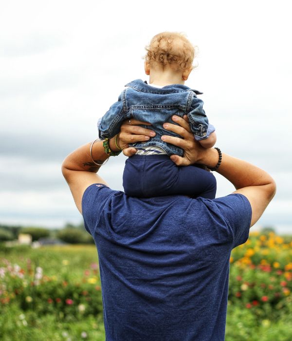a father carrying his young son on his shoulders