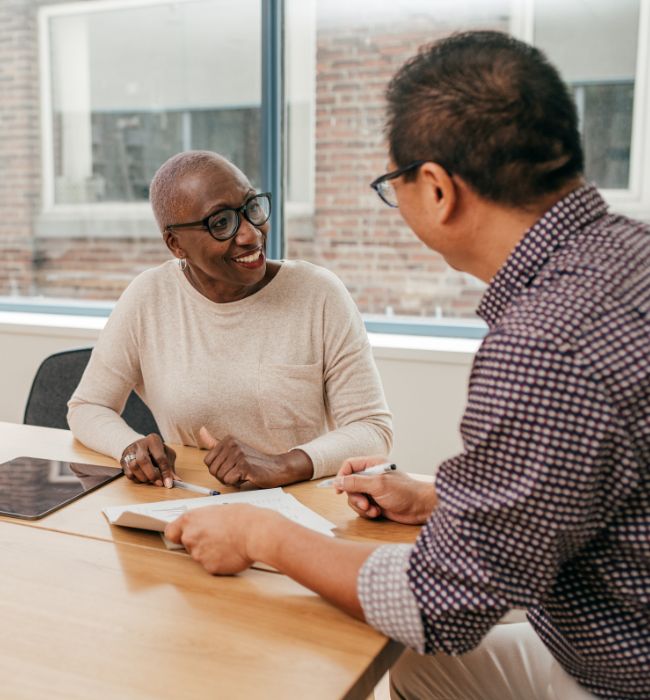 two people sitting at a desk discussing a personal injury settlement